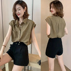 Camisa feminina sem manga com bolsos frontais e botões, em tom neutro, combinada com short preto de cintura alta.